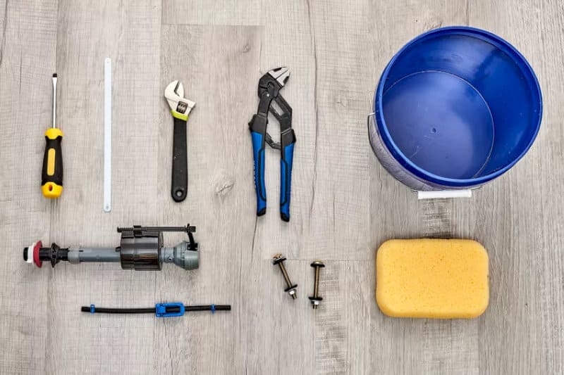 Tuốc nơ vít, mỏ lết, kìm, van xả, ốc cố định, xô nước và miếng bọt biển để lắp đặt bồn cầu