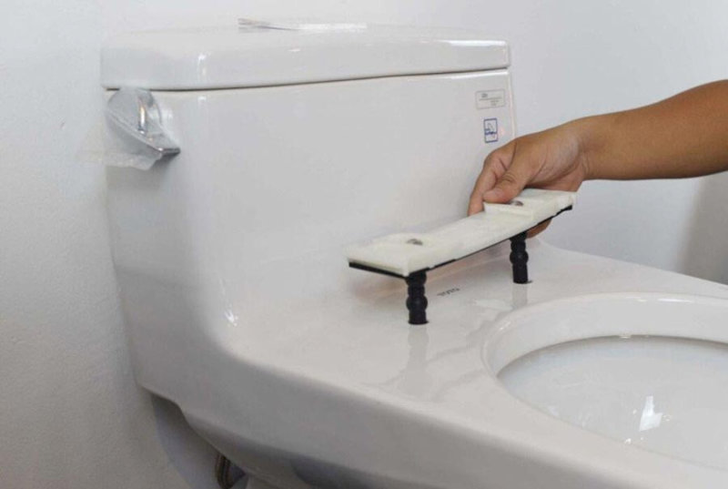 Lắp bản lề bồn cầu mới với thao tác tỉ mỉ, đảm bảo độ chắc chắn cho phần nắp trong quá trình sử dụng.