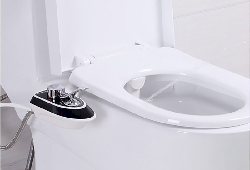 Bồn cầu trắng thông minh với vòi rửa cơ điều khiển bên cạnh và chỗ điều chỉnh màu đen