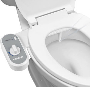 Bồn cầu trắng với nắp rửa cơ màu xám gắn bên cạnh.